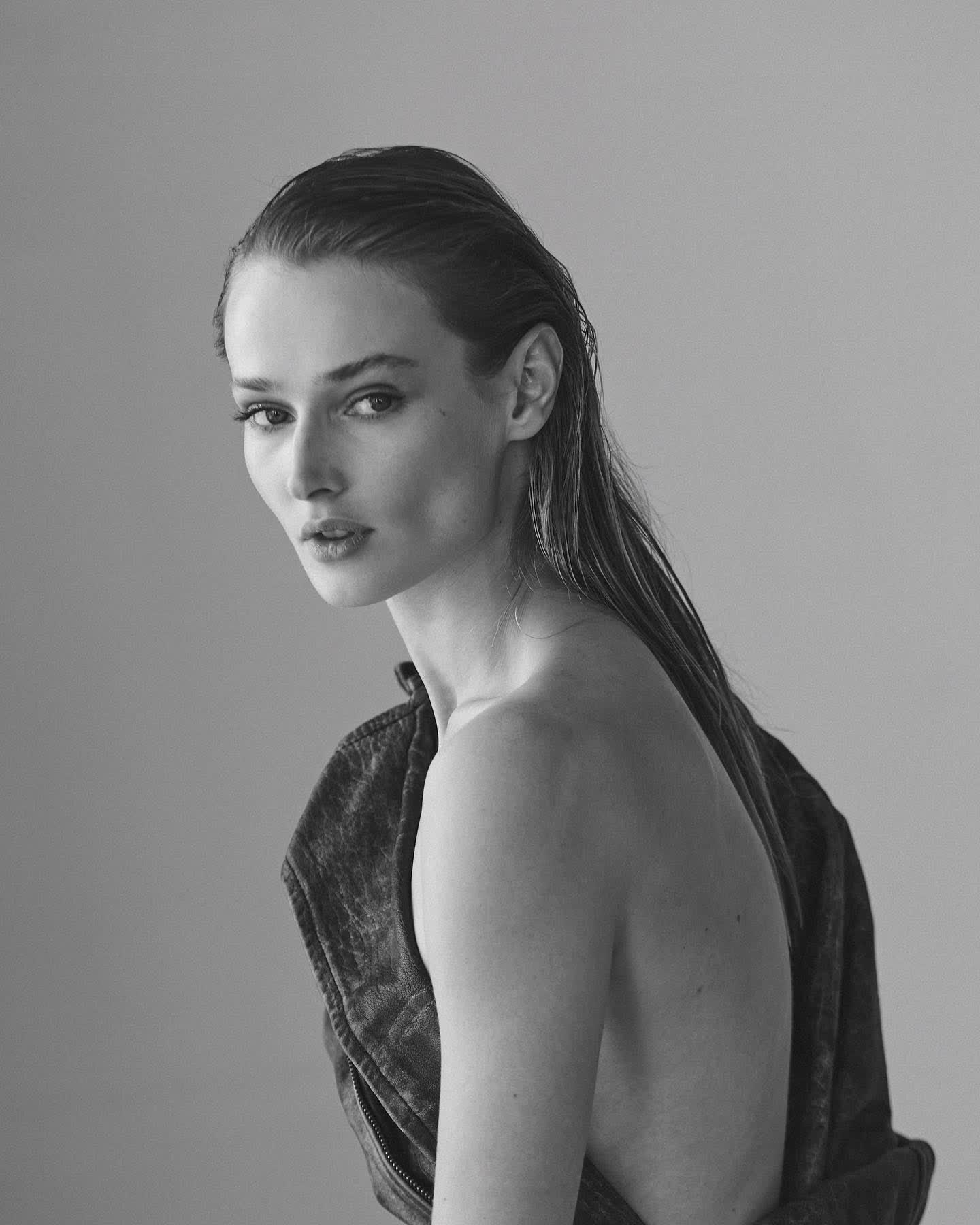 Anastasiia Koval in a silver gown, turned in profile against a dark background.