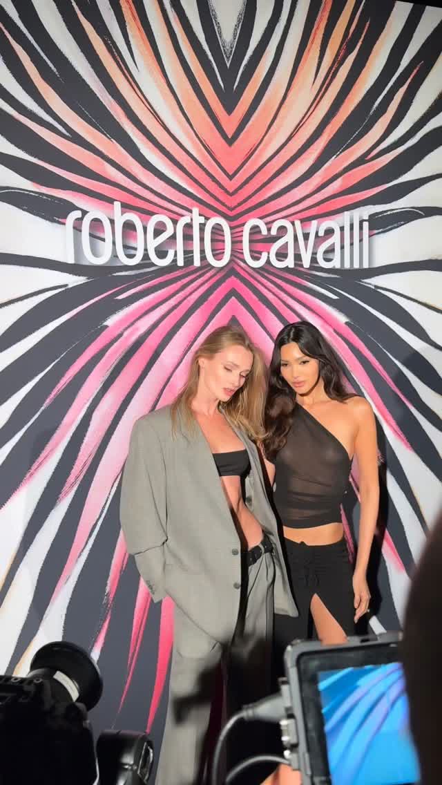 Anastasiia Koval beside a second model in a graphic pink and black studio campaign frame.